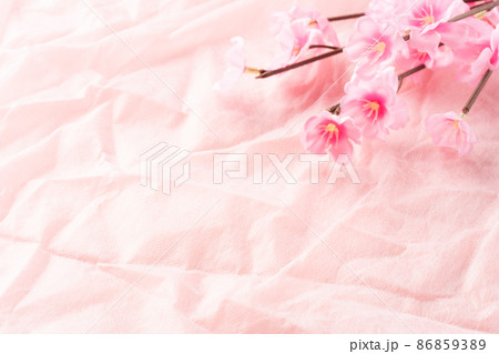 桃の花の造花とピンクの布の背景素材 86859389