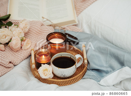 Tray of coffee and candles on bed. Tray of coffee and candles on bed. 86860665