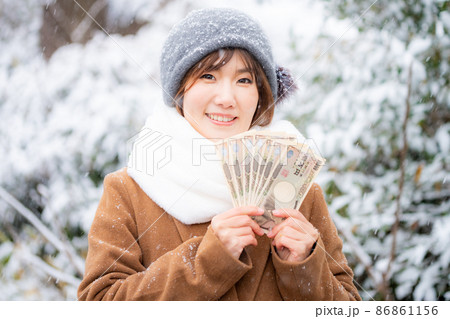 冬の屋外で現金を手に持つ女性 冬の屋外で現金を手に持つ女性 86861156