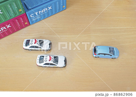 3つのコンテナと2台のパトカーに追跡されている乗用車 3つのコンテナと2台のパトカーに追跡されている乗用車 86862906
