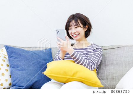 自宅でスマートフォンを使う女性 86863739