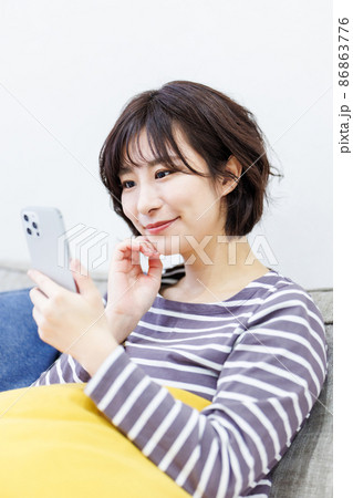 自宅でスマートフォンを使う女性 86863776