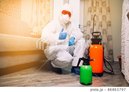 Exterminator in work clothes showing thumbs up. Fight against insects in apartments and houses. Disinsection of premises 86863797
