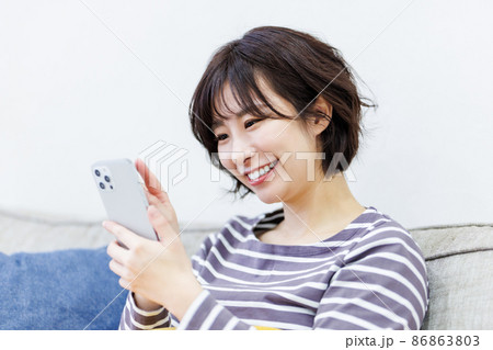 自宅でスマートフォンを使う女性 86863803