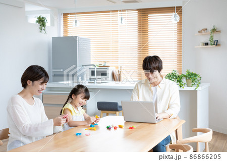 ダイニングテーブルで粘土で遊ぶ小学生の女の子とママ パソコン作業をするパパ ダイニングテーブルで粘土で遊ぶ小学生の女の子とママ パソコン作業をするパパ 86866205