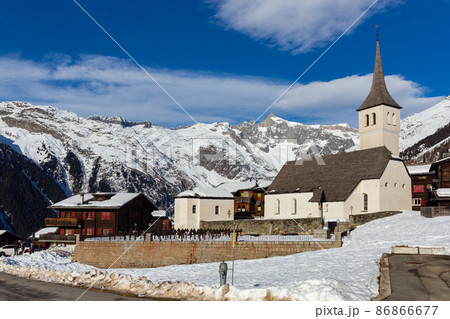 Winter view of Swiss township of Bellwald with parish church 86866677