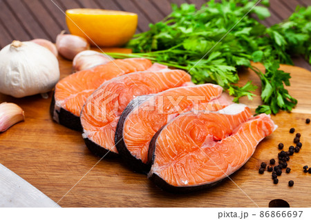 Raw salmon steaks with lemon, parsley, garlic Raw salmon steaks with lemon, parsley, garlic 86866697