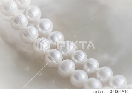 Nature white string of pearls on marble background in soft focus, with highlights Nature white string of pearls on marble background in soft focus, with highlights 86866916