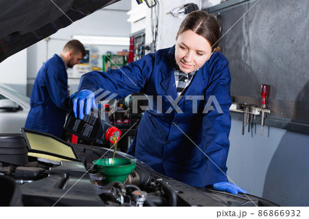 Young woman master is replacing the oil in the car in workshop. 86866932