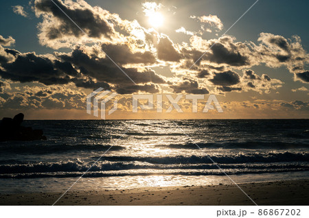 夕日に照らされる浜辺 86867202