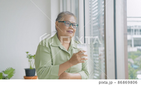 Holiday concept. Asian old woman drinking milk at home. 4k Resolution. Holiday concept. Asian old woman drinking milk at home. 4k Resolution. 86869806