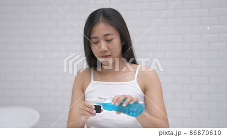 Daily routine concept. Young Asian woman gargling in the bathroom. 4k Resolution. 86870610