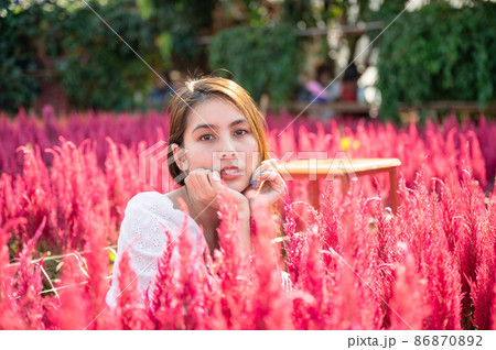 Beautiful young asian woman sitting in cockscomb flower garden 86870892
