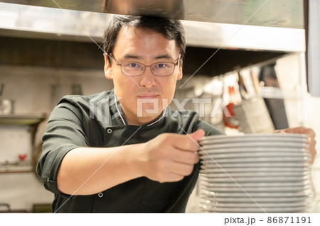 飲食店で料理の準備をする男性スタッフ 飲食店で料理の準備をする男性スタッフ 86871191