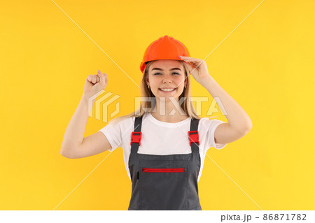 Builder woman on yellow background, equality concept 86871782