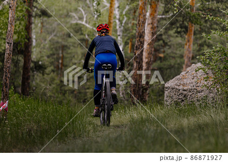 back woman riding mountain bike on forest trail 86871927