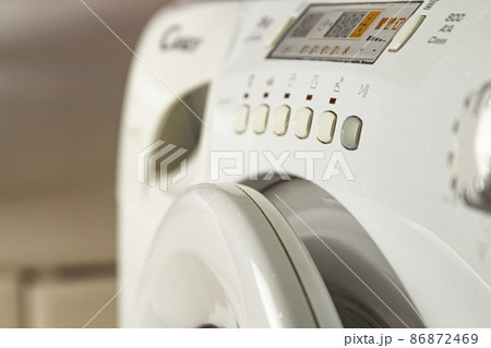 Modern washing machine with laundry. Close-up of control buttons and panel Modern washing machine with laundry. Close-up of control buttons and panel 86872469