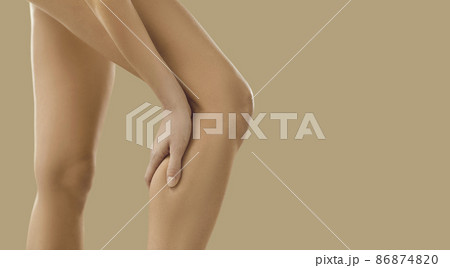 Crop close up image of unhealthy naked woman having ache in leg. Pain in calf concept. Unwell female suffer from acute spasm or cramp. Torn or stretched muscle problem. Healthcare and rehabilitation. Crop close up image of unhealthy naked woman having ache in leg. Pain in calf concept. Unwell female suffer from acute spasm or cramp. Torn or stretched muscle problem. Healthcare and rehabilitation. 86874820