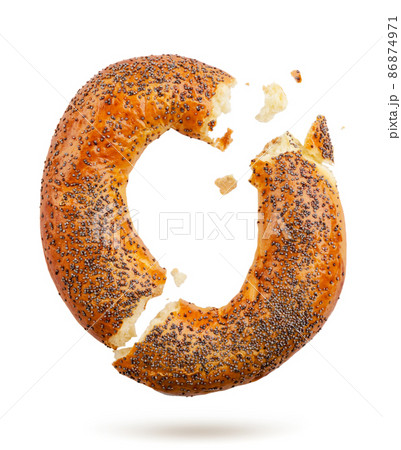 Bagel with poppy seeds broken falls on a white background. Isolated 86874971
