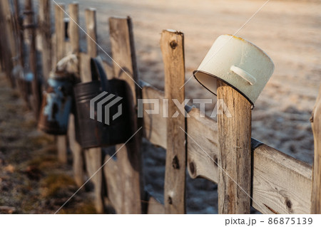 Vintage kitchen utensils on the wooden fence. Rustic garden decor. 86875139