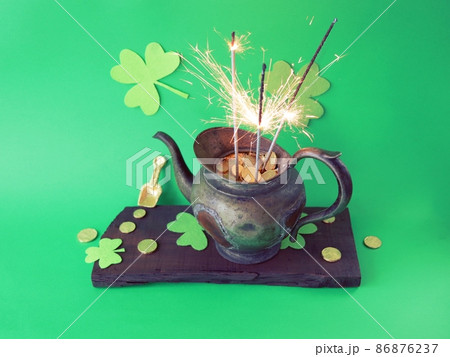Patrick's Day, vintage pot with gold coins and burning sparklers, on a green background with shamrocks, holiday, party, interior decoration 86876237