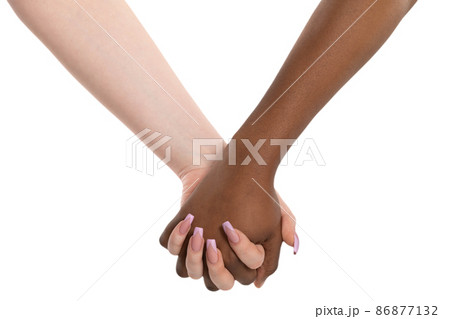 Two hands in a cordial embrace. Handshake. Two women holding hands. Two hands of different races in a loving embrace. African and European. Two hands in a cordial embrace. Handshake. Two women holding hands. Two hands of different races in a loving embrace. African and European. 86877132