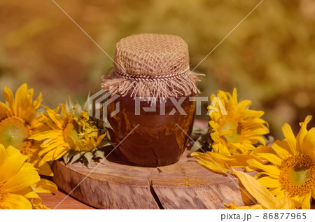 Honey in jar with honey dipper on rustic wooden table background Honey in jar with honey dipper on rustic wooden table background 86877965