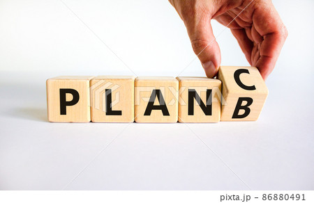 Plan B or C symbol. Businessman turns a wooden cube and changes words Plan B to Plan C. Beautiful white table, white background, copy space. Business and Plan B or C planning concept. 86880491