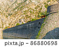 Detail of the ancient stone wall of the Gurdic Gate near the pond water in the old town of Kotor, Montenegro 86880698