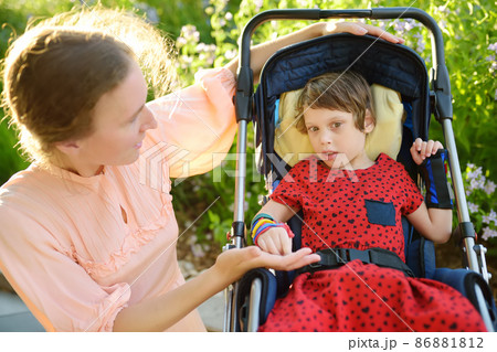 Little girl cp Woman with disabled girl in a wheelchair...の写真素材 [86881812] - PIXTA