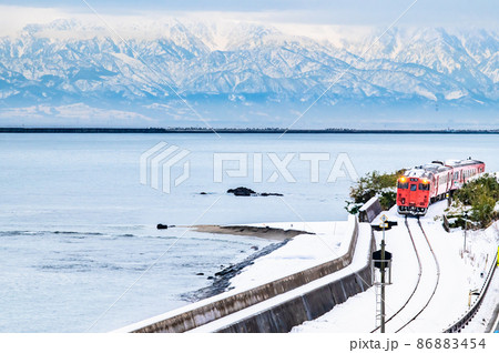 富山県　冬の氷見線（雨晴海岸）　～立山連峰をバックに走る気動車～ 86883454