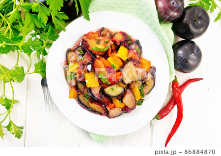 Eggplant with plums in plate on board top 86884870