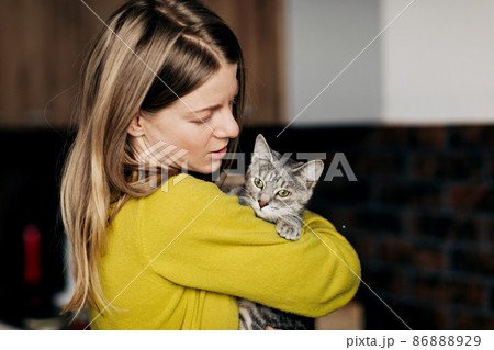 Young woman in home clothes hugging her cat at home Young woman in home clothes hugging her cat at home 86888929