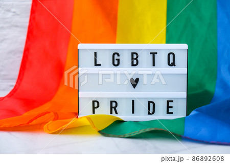 Rainbow flag with lightbox and text LGBTQ PRIDE. Rainbow lgbtq flag made from silk material. Symbol of LGBTQ pride month. Equal rights. Peace and freedom 86892608