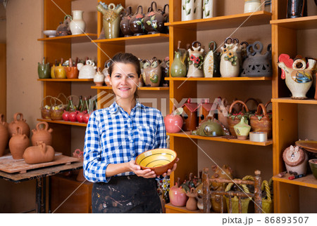 Girl showing finished ceramic production 86893507