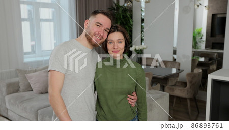 Happy young family couple looking at camera, showing keys form new apartment. Feeling excited or purchasing own house or moving into rental apartmant. Real estate concept. Happy young family couple looking at camera, showing keys form new apartment. Feeling excited or purchasing own house or moving into rental apartmant. Real estate concept. 86893761