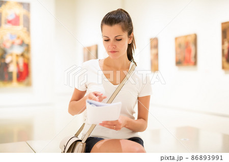 Young woman looking at artworks in museum Young woman looking at artworks in museum 86893991