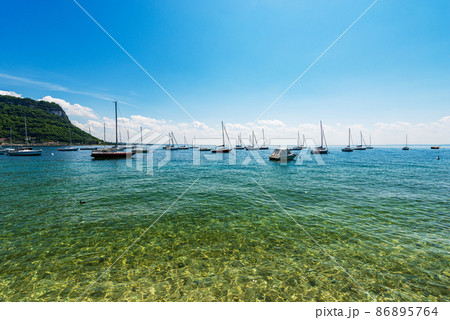 Many Boats Moored on Lake Garda in front of Garda Town - Verona Veneto Italy Many Boats Moored on Lake Garda in front of Garda Town - Verona Veneto Italy 86895764