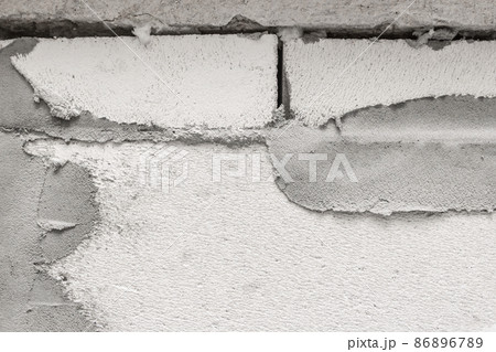 Old cement wall made of brick white silicate blocks in need of repair and reconstruction, unfinished construction of the house Old cement wall made of brick white silicate blocks in need of repair and reconstruction, unfinished construction of the house 86896789