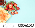 Top view of toast strawberries and jam on isolated pastel background with copy space. 86896898