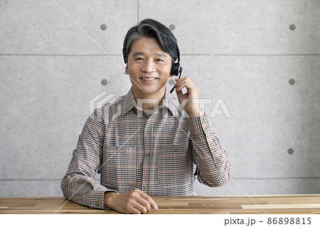 ヘッドセットをつけたカメラ目線の50代の男性 ヘッドセットをつけたカメラ目線の50代の男性 86898815