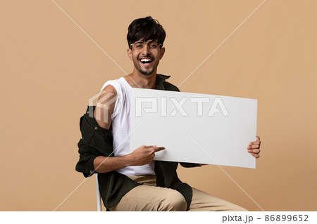 Healthy indian guy got vaccinated, holding empty advertising board 86899652