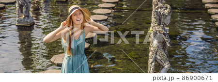 Young woman tourist in Taman Tirtagangga, Water palace, Water park, Bali Indonesia BANNER, LONG FORMAT 86900671