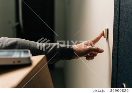 Close-up hands of unrecognizable delivery man ringing doorbell of customer apartment holding cardboard box, contactless payment POS wireless terminal for card paying. Concept of online shopping. 86900826
