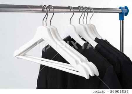 Black T-shirt on hangers on metal rack isolated on white background Black T-shirt on hangers on metal rack isolated on white background 86901882