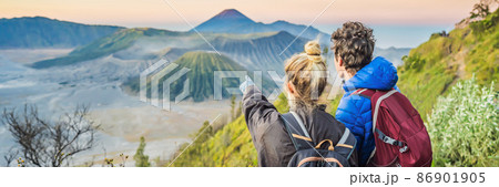 BANNER, LONG FORMAT Young couple man and woman meet the sunrise at the Bromo Tengger Semeru National Park on the Java Island, Indonesia. They enjoy magnificent view on the Bromo or Gunung Bromo on 86901905