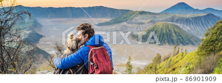 BANNER, LONG FORMAT Young couple man and woman meet the sunrise at the Bromo Tengger Semeru National Park on the Java Island, Indonesia. They enjoy magnificent view on the Bromo or Gunung Bromo on 86901909