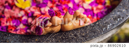 Attractive Young woman in bath with petals of tropical flowers and aroma oils. Spa treatments for skin rejuvenation. Alluring woman in Spa salon. Girl relaxing in bathtub with flower petals. Luxury Attractive Young woman in bath with petals of tropical flowers and aroma oils. Spa treatments for skin rejuvenation. Alluring woman in Spa salon. Girl relaxing in bathtub with flower petals. Luxury 86902610