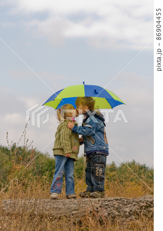 Little boy and girl with umbrella Little boy and girl with umbrella 86904455