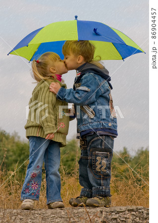 Little boy and girl with umbrella 86904457